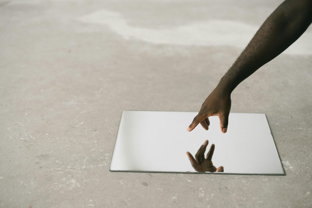 Person touching glass on concrete floor