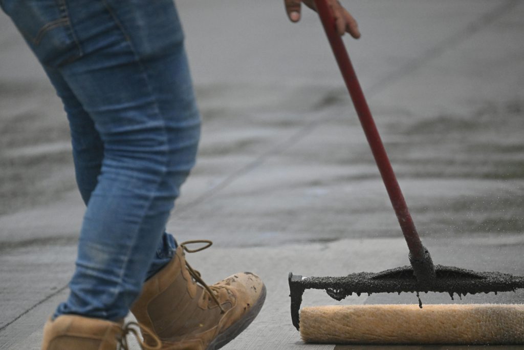 Person sealing concrete