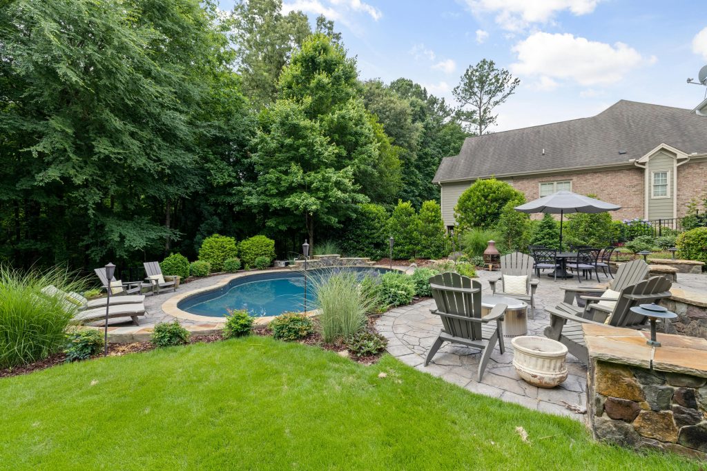 Stone patio with a pool in the backyard