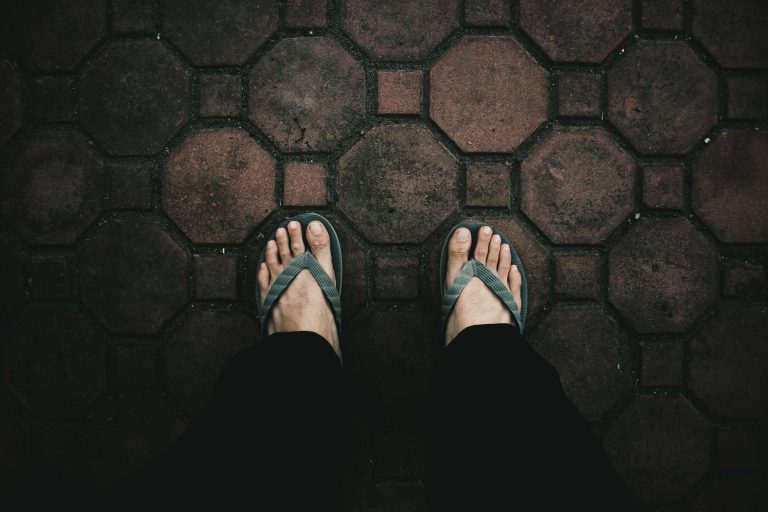 Person standing on pavers in flip flops